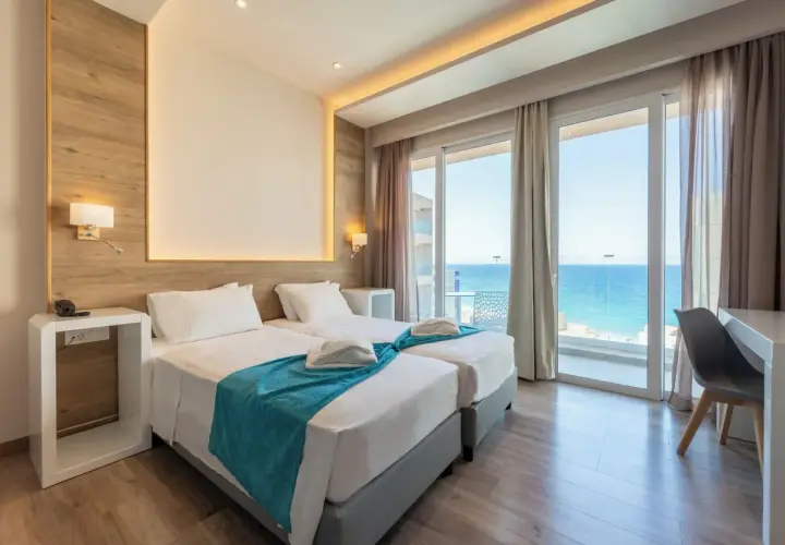 Pokój hotelowy z dwoma łóżkami i widokiem na morze. Idealne miejsce na relaks, jak w **pefkos**.
