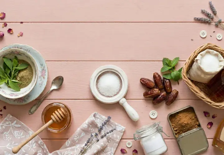 Stevia, miód, daktyle, cukier i syrop klonowy – co jest zdrowsze od cukru? Kompozycja na różowym tle.