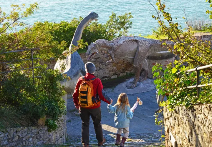 Un padre e una bambina esplorano dinosauri in Liguria, un'avventura indimenticabile per tutta la famiglia.