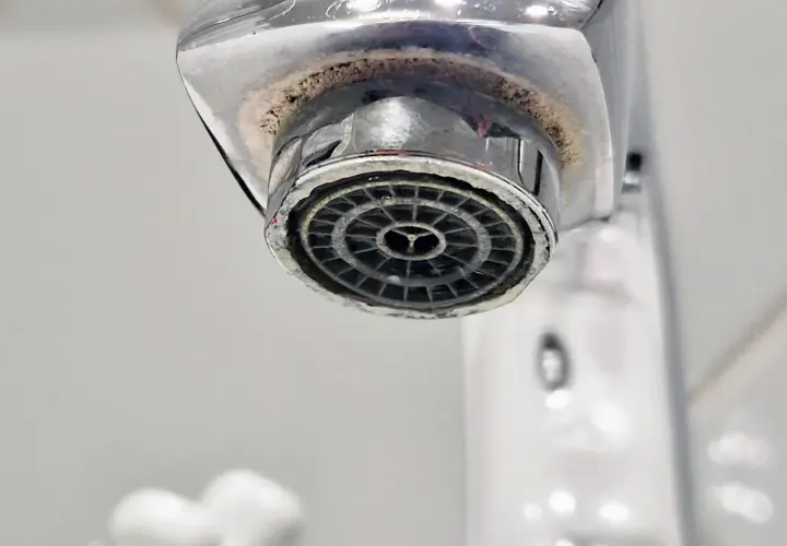 Zakamieniony perlator kranu z widocznym osadem wapiennym.