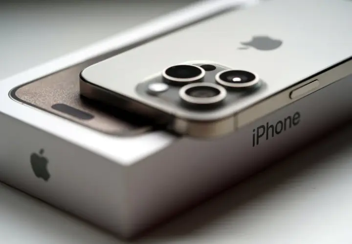 Nowy iPhone 15 na pudełku. Zbliżenie na moduł aparatów i logo Apple. Poznaj jego wymiary.