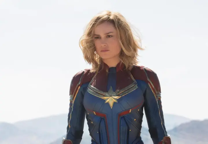 Captain Marvel, en armure bleue et rouge, prête à défendre la Terre. Elle est la réponse à qui est Captain Marvel.