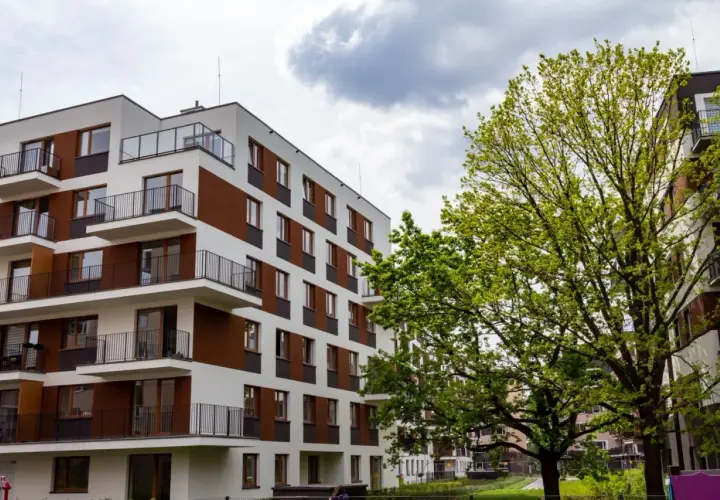 Nowoczesne bloki mieszkalne w stylu riviera park, z balkonami i zielenią.