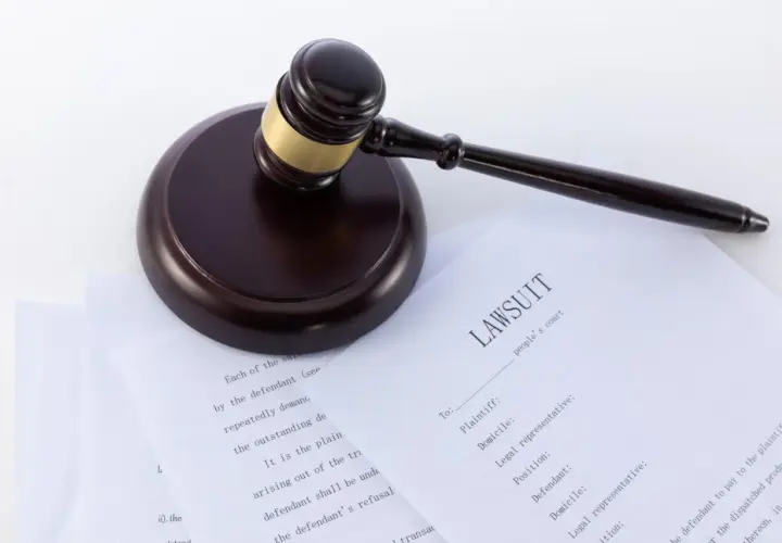 Młotek sędziowski na dokumentach z nagłówkiem "LAWSUIT". Wzór pozwu o alimenty, gotowy do wypełnienia.