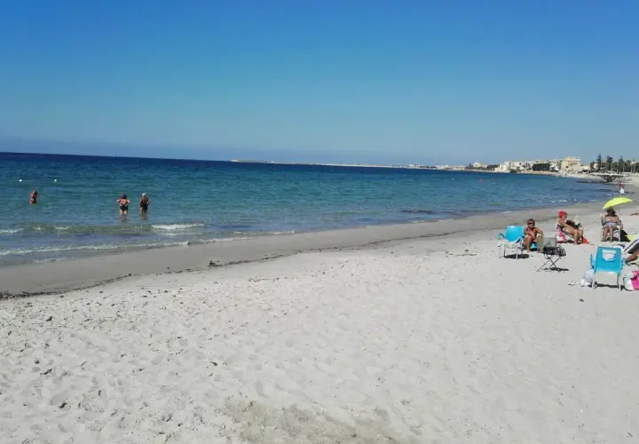 Plage de Mazara del Vallo, Italie. Des baigneurs profitent de la mer calme et du soleil sur le sable fin.