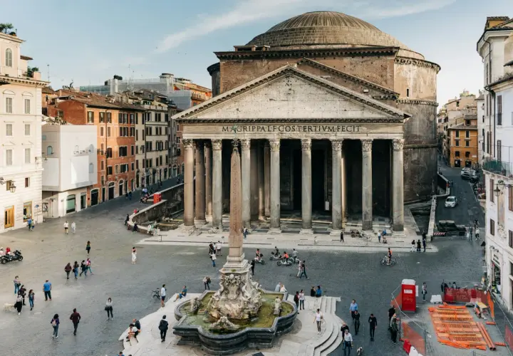 La Piazza della Rotonda à Rome, avec le majestueux Panthéon et sa fontaine. Des passants profitent de la journée ensoleillée.