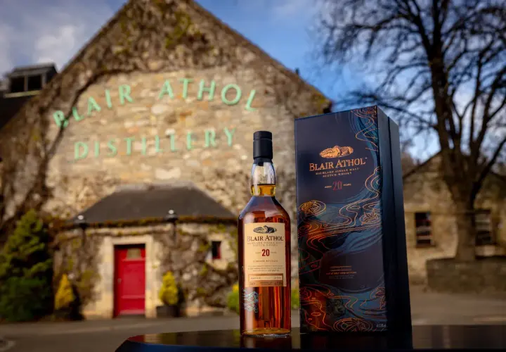 Bouteille de whisky Blair Athol 20 ans et sa boîte devant la distillerie.