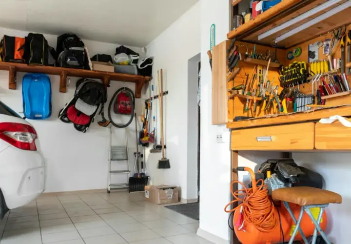 Werkstatt einrichten: Ordnung im Garage mit Werkzeugwand, Kompressor und Auto.
