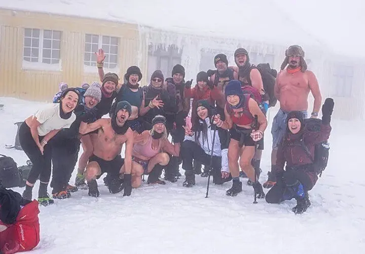 Grupa entuzjastów morsowania w stylu Wim Hof Polska pozuje do zdjęcia na mrozie.