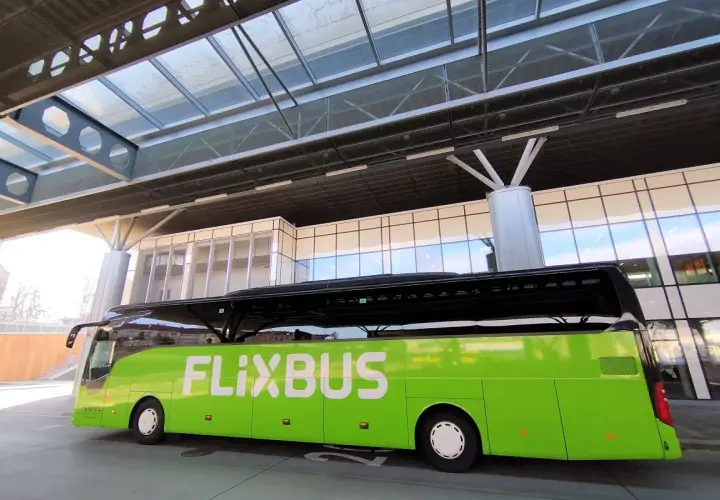 Zielony autobus FlixBus czeka na pasażerów na nowoczesnym dworcu. To idealne miejsce na rozpoczęcie podróży, bo flixbus przystanki są dobrze zorganizowane.