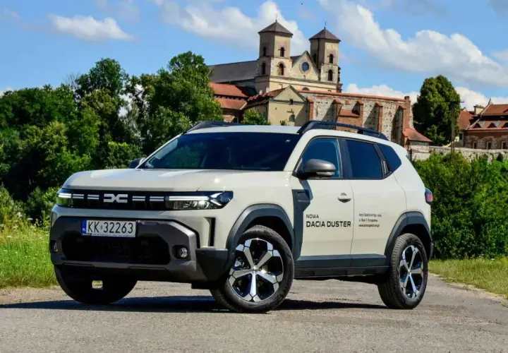Nowa Dacia Duster hybryda na tle zabytkowego klasztoru.