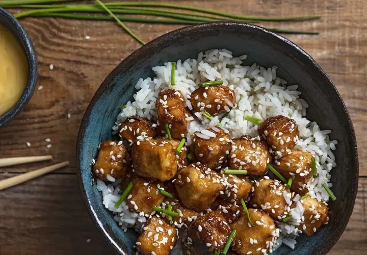 Pyszny stir fry z tofu, podany z ryżem i posypany sezamem. Idealny posiłek dla wegan.
