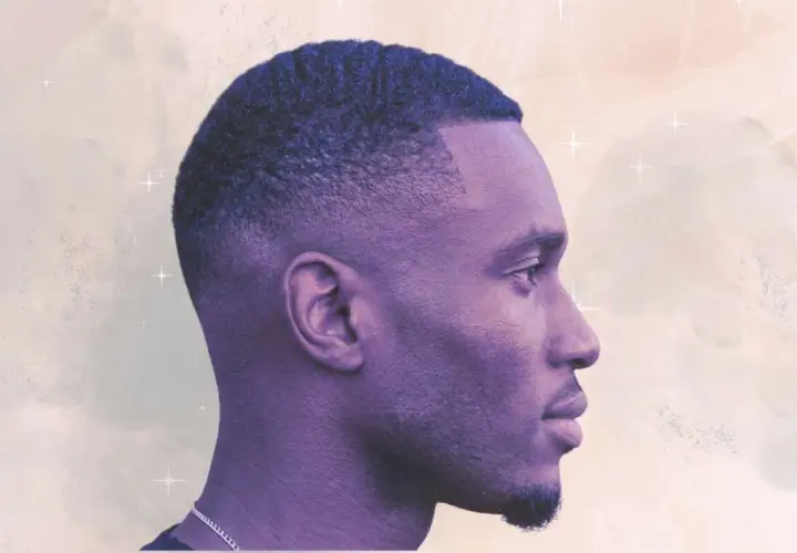 Perfil de hombre con un corte de pelo tuper fade, ondas definidas y barba corta.