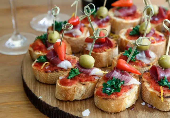 Pyszne tapas z szynką, oliwkami i papryczką, idealne do **pliska brandy z czym pić**.