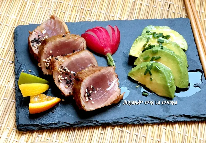 Tataki de bonito sellado con sésamo, acompañado de aguacate, rábano y cítricos.