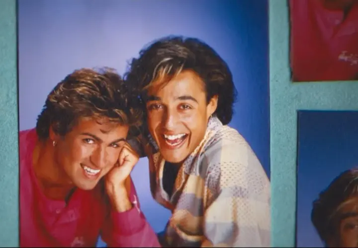 George Michael i Andrew Ridgeley z Wham! uśmiechają się radośnie. Ich klasyczne george michael utwory wciąż brzmią w naszych sercach.