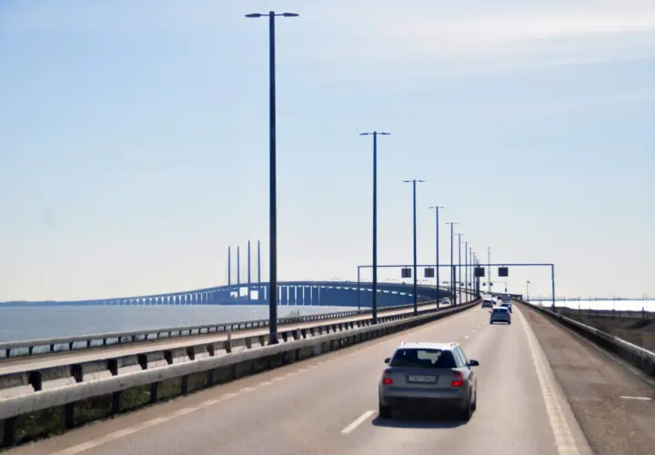 Jadąc mostem Malmo Kopenhaga, mijamy rzędy latarni i inne samochody.