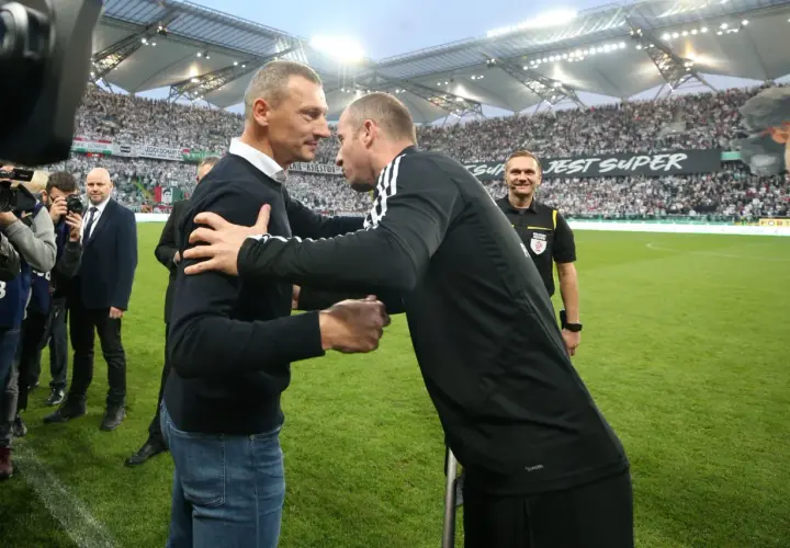Mauricio Pellegrino wita się z trenerem na tle trybun stadionu.