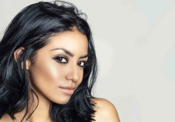 Mujer con piel morena, ojos marrones y cabello negro azabache. Un color de pelo para piel morena que realza su belleza natural.
