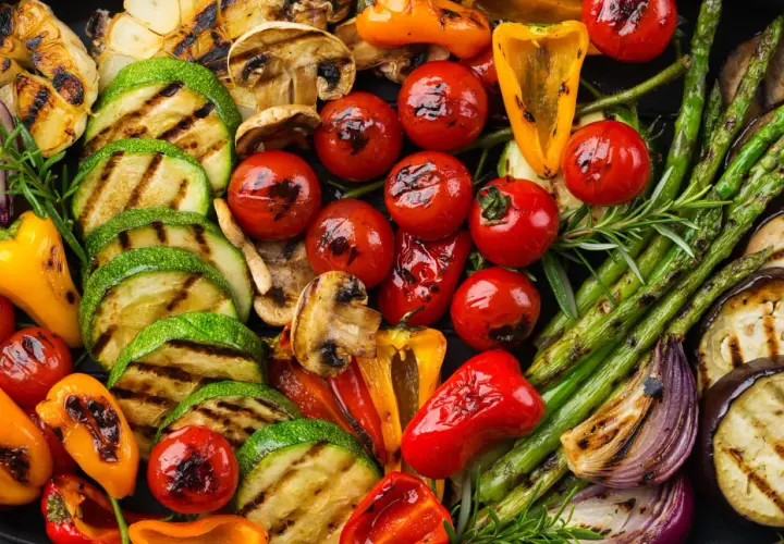 Un assortiment coloré de légumes grillés, parfait en accompagnement barbecue : courgettes, tomates cerises, poivrons, asperges, champignons, aubergines et oignons rouges.