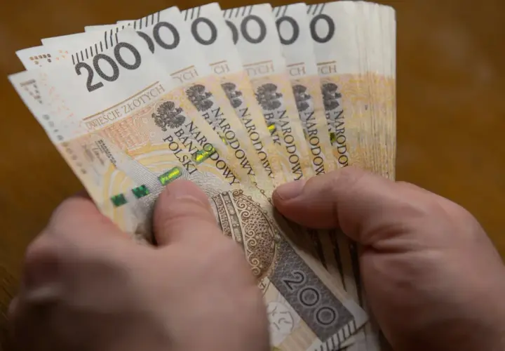 Dłonie trzymają stos banknotów po 200 zł. To hojna darowizna w pierwszej linii, która pomoże potrzebującym.