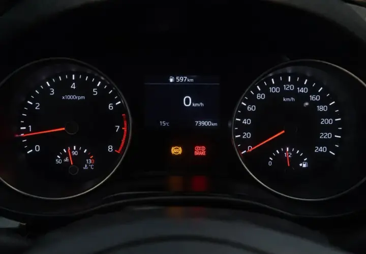 Cruscotto auto con tachimetro, contagiri e indicatori. La spia freni è accesa, segnalando un potenziale problema.