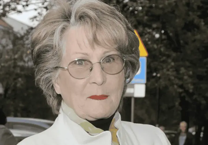 Irena Santor w okularach, z czerwoną szminką na ustach, w białej kurtce. Myśli o swoich dzieciach.