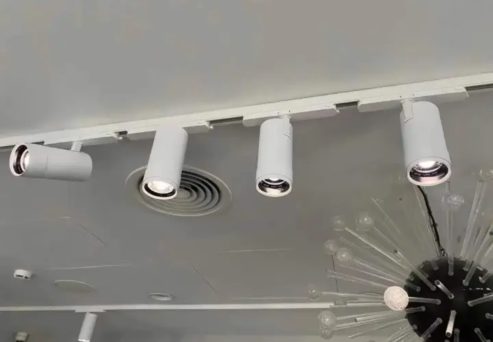 Barra focos techo blanca con focos cilíndricos dirigibles, iluminando un espacio moderno.