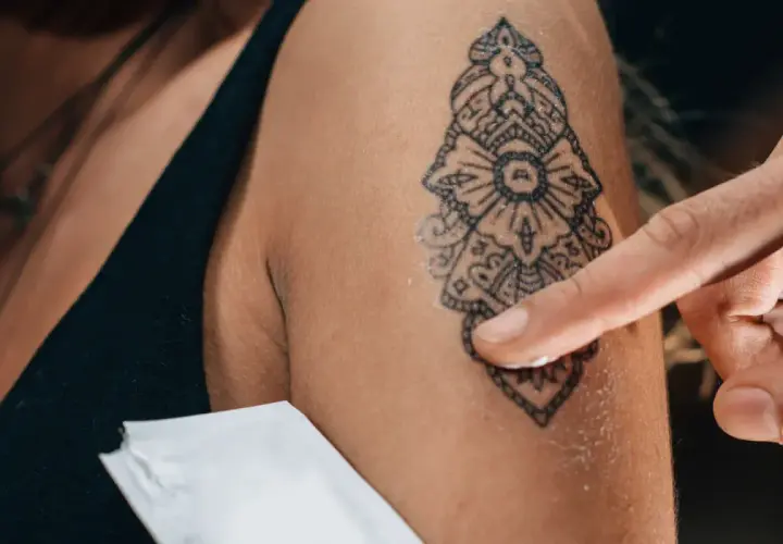 Application d'une crème sur un nouveau tatouage. Pour savoir si un tatouage est cicatrisé, observez la peau : elle ne doit plus être rouge, gonflée ni suinter.