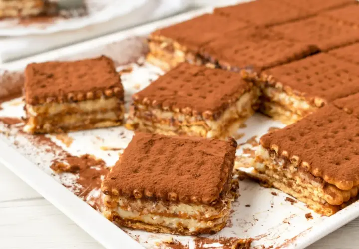 Pyszne, tanie ciasto bez pieczenia z herbatnikami, posypane kakao. Idealne na deser.