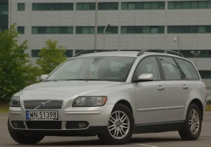 Srebrne Volvo V50 1.6 diesel na tle nowoczesnego budynku.