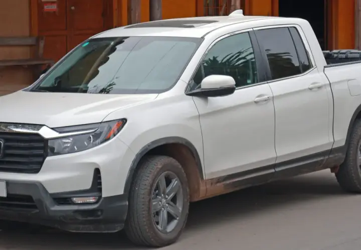 Biały Honda Ridgeline z błotem na progach, gotowy na przygodę.