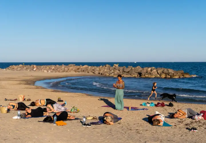 Cours de yoga sur la plage de Frontignan avec vue sur la mer et les étangs.