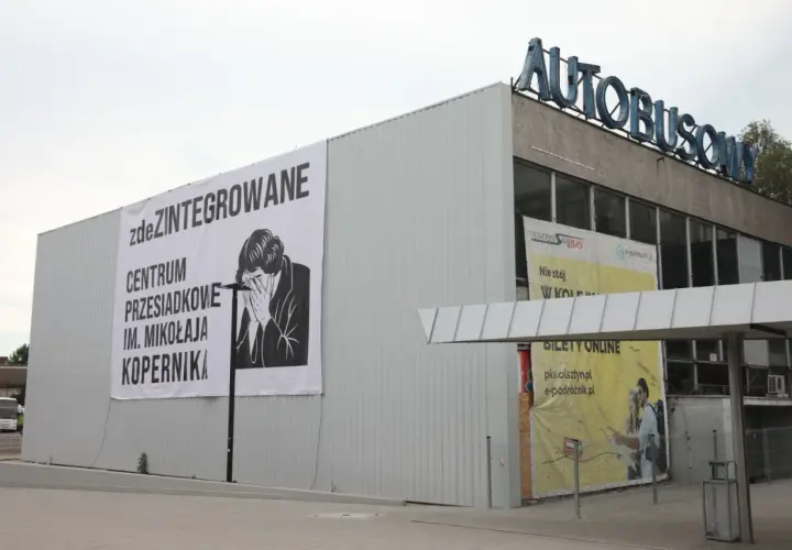 Budynek dworca autobusowego z banerem "zdeZINTEGROWANE CENTRUM PRZESIADKOWE IM. MIKOŁAJA KOPERNIKA".