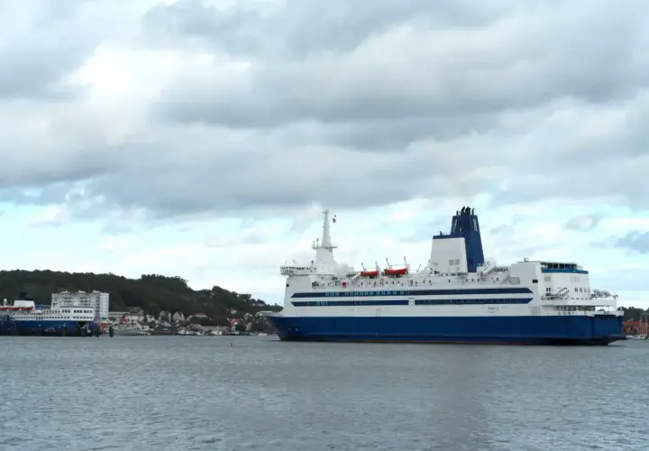 Duży prom pasażerski, podobny do tych kursujących na trasie Dover, zacumowany przy brzegu.