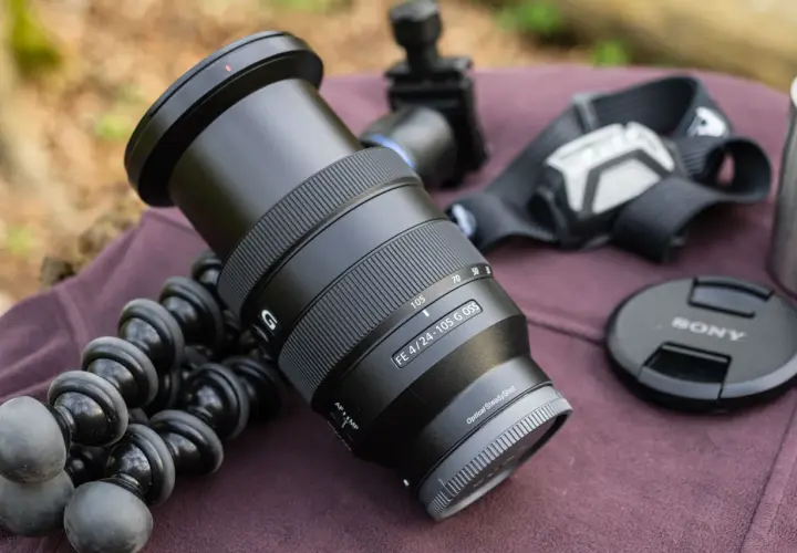 Obiektyw Sony FE 4/24-105 G OSS, idealny do krajobrazu, leży obok statywu i akcesoriów.