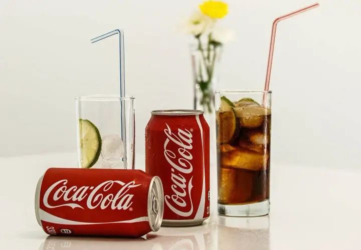 Puszki i szklanki z Coca-Colą, lodem i limonką. Zastanawiasz się, ile kalorii ma Coca-Cola?