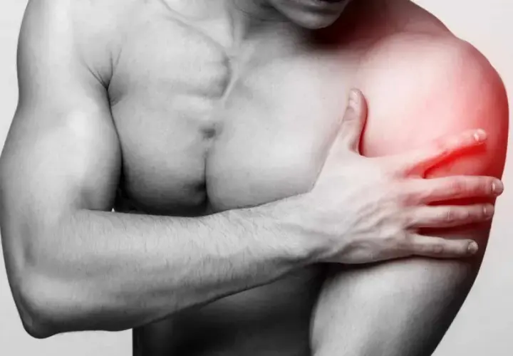 Un homme tient son épaule douloureuse, une longue portion de son bras est marquée en rouge pour indiquer la douleur.