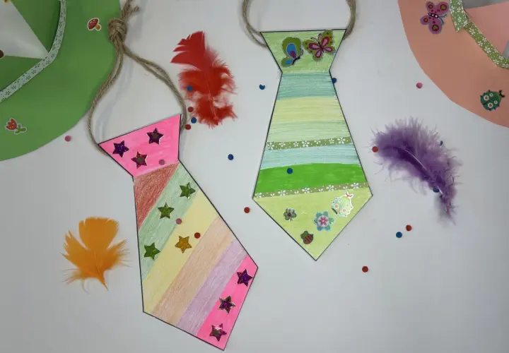 Bunte Krawatten basteln mit Federn und Stickern. Eine pinke und eine grüne Krawatte, dekoriert mit Sternen und Schmetterlingen.