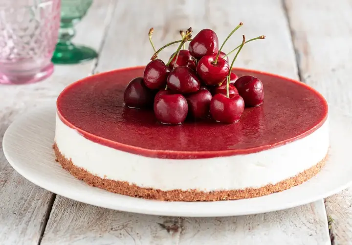 Cheesecake ai ciliegie, una delle torte più buone da fare in casa. Base croccante, crema vellutata e topping di ciliegie fresche.