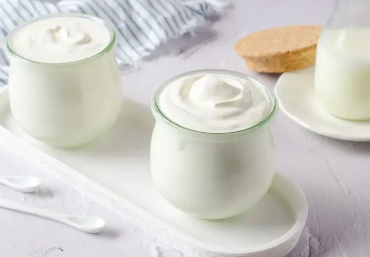 Dos frascos de yogur casero cremoso, listos para disfrutar. Aprende como hacer yogurt casero.