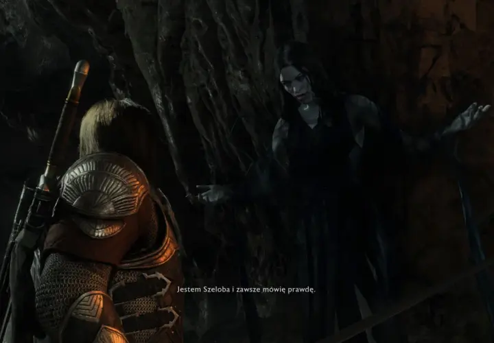 Szeloba, widmowa postać z gry Shadow of War, przemawia do bohatera w mrocznej jaskini.