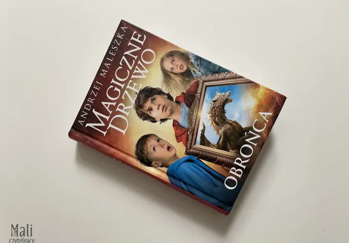 Okładka książki "Magiczne drzewo. Obrońca" z Andrzejem Maleszką. Trójka dzieci patrzy z zaciekawieniem na smoka w ramie.