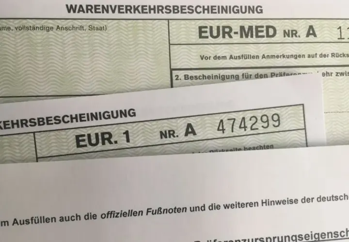 Zwei Warenverkehrsbescheinigungen, eine mit "EUR-MED" und eine mit "EUR. 1", sind übereinander gelegt.