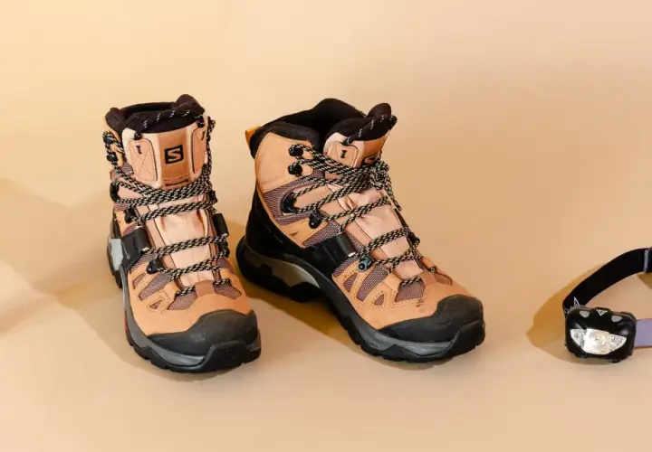 Hiking boots, insect repellent, and a headlamp are laid out. When choosing wanderschuhe worauf achten? Comfort and durability are key for any adventure.