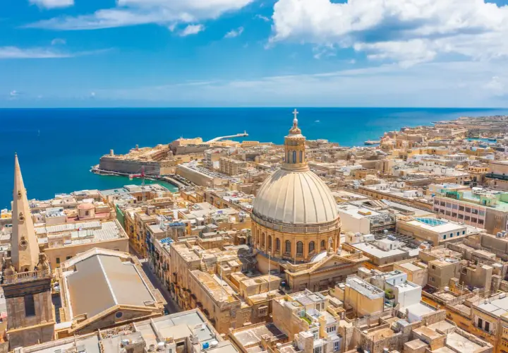 Malta w marcu: słoneczna pogoda nad Vallettą, z widokiem na morze, kopułę katedry i zabytkowe budynki.