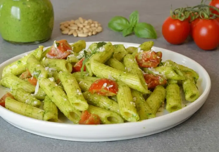 Penne al pesto di rucola con pomodorini freschi e pinoli tostati. Un piatto colorato e saporito.