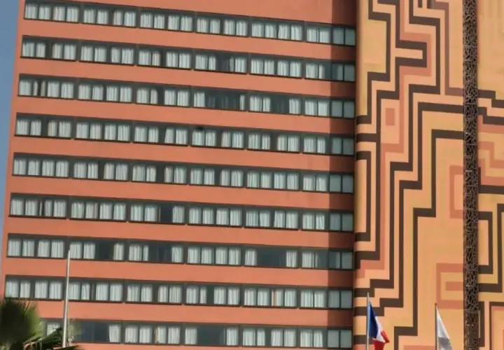 Façade d'un hôtel orange avec des motifs géométriques et des fenêtres.