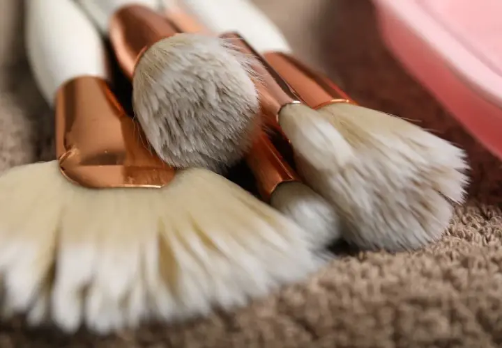 Set de brochas de maquillaje con mangos blancos y detalles dorados, listas para aprender como limpiar brochas de maquillaje.
