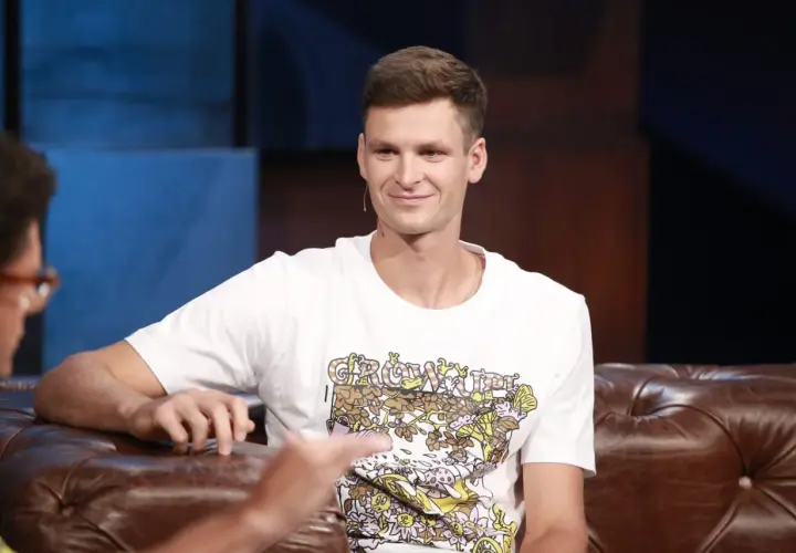 Uśmiechnięty Hubert Hurkacz, zapytany ile ma lat, siedzi na kanapie w studiu.